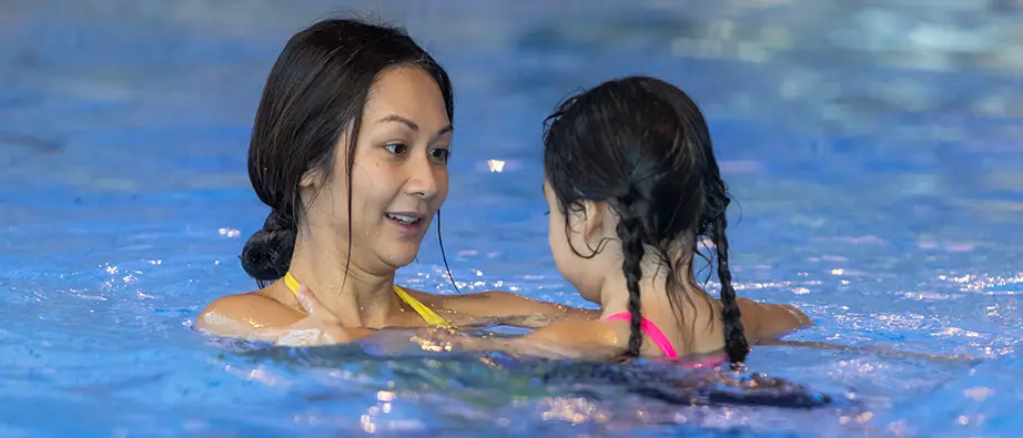 En kvinna och ett barn badar tillsammans.
